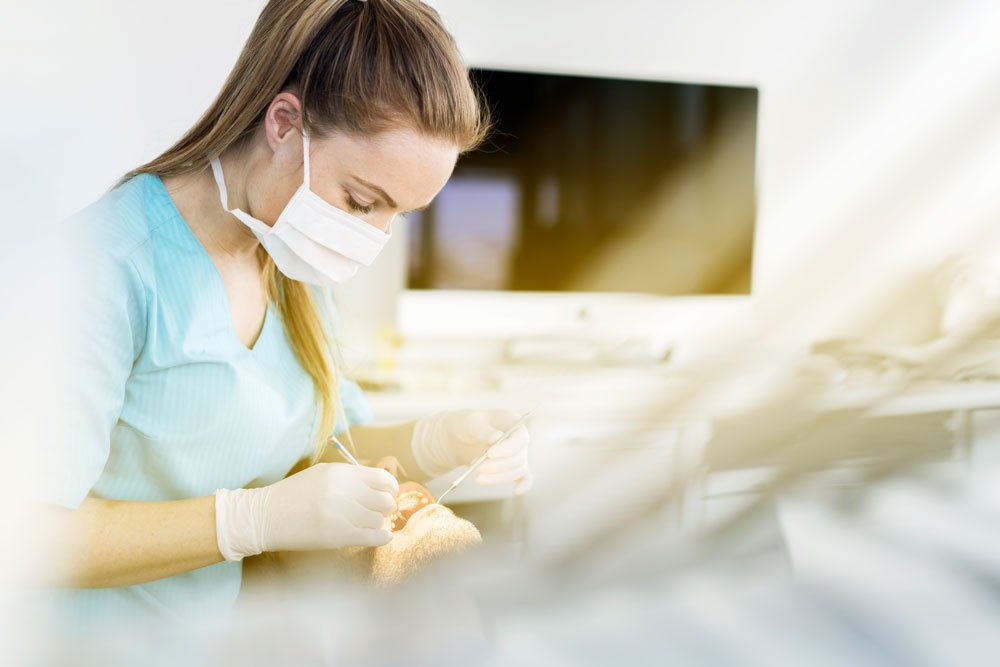 En kvinnlig tandläkare som har en patient.